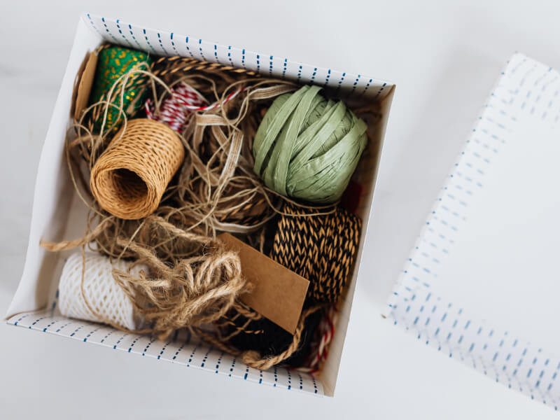 a white box full with a variety of coloured threads and strings of different sizes.